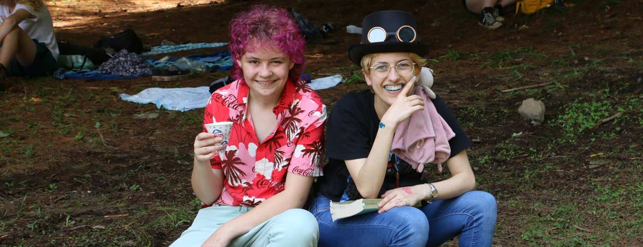 Camper with red hair and snow cone with camper wearing top hat.