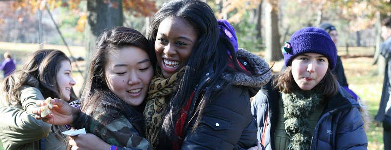 Teens embrace at a fall reunion at the park