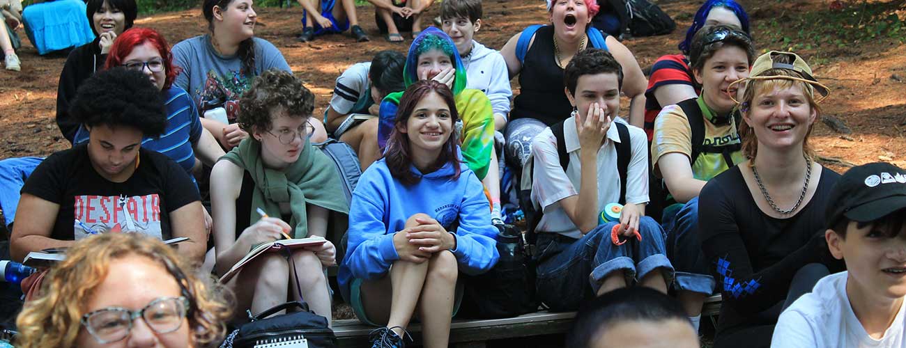 Group of teen campers laughing at the outdoor amphitheater