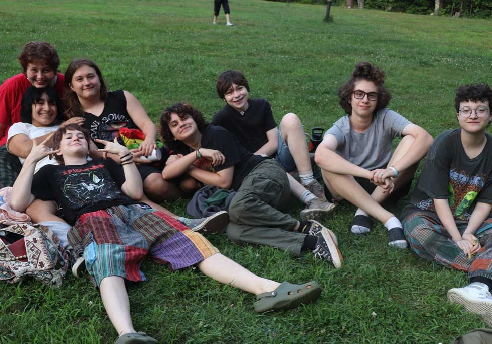 Group of teens on grass hanging out relaxing together